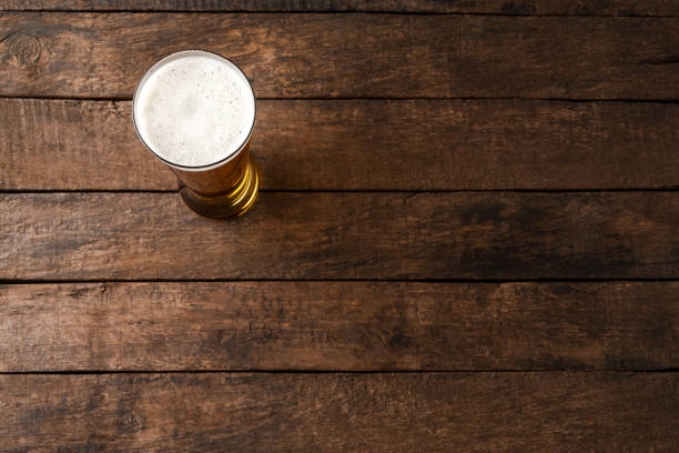 istock Beer glass on wooden table. Close up 1306478292