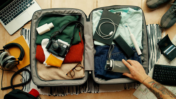 hombre empaca maleta lista para viaje de aventura - empaquetar fotografías e imágenes de stock