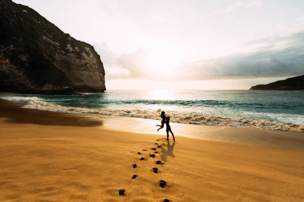 amanti sulla costa. l'uomo sollevò la ragazza tra le sue braccia. silhouette di coppia amorevole sul mare. una coppia innamorata al tramonto. amanti della silhouette. vacanza al mare. viaggio di nozze. spazio di copia - arms lifted foto e immagini stock