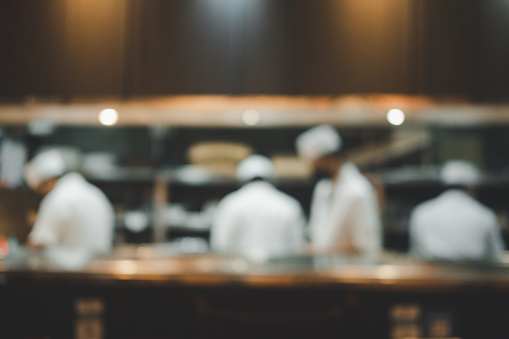 Abstract blurry background of chef preparing  cook sushi and counter bar in Japan restaurant.