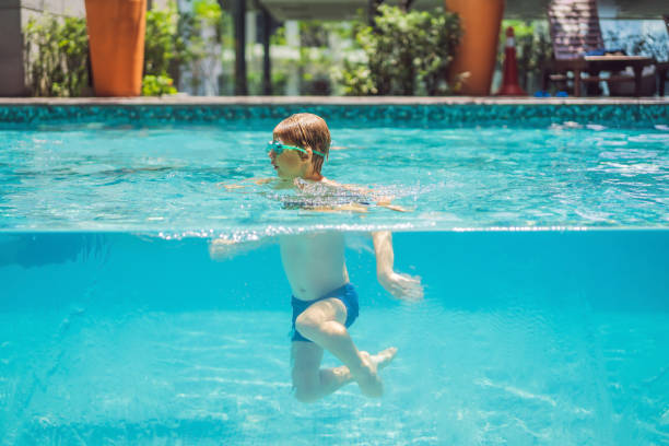 istock Boy having fun playing underwater in swimming pool on summer vacation 1306486463