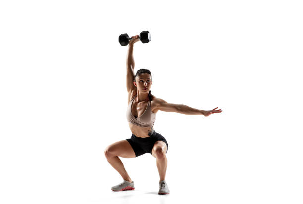 Caucasian professional female athlete training isolated on white studio background. Muscular, sportive woman.