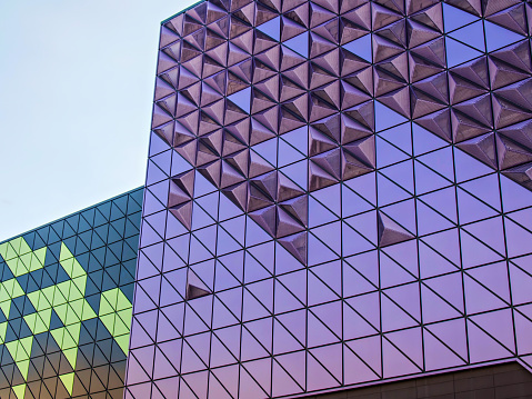 Facade of a modern building. Purple and lilac geometric shapes.