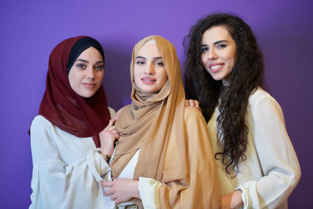 istock Young muslim women posing on purple background 1306493997