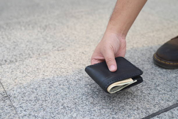 กระเป๋าเงินหล่นจากกระเป๋าและมือผู้ชายหยิบมันขึ้นมาจากพื้นดิน ภาพสต็อก -  ดาวน์โหลดรูปภาพตอนนี้ - iStock