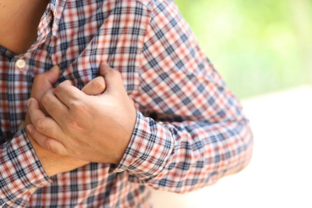 Man having chest pain - heart attack, outdoors stock photo