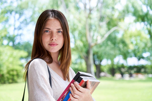 istock Woman holding books while standing outdoors 1306497221