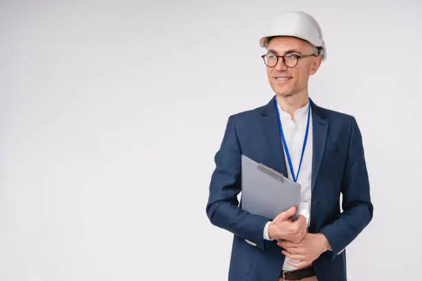 Confident mature caucasian engineer in hardhat with clipboard isolated over white background