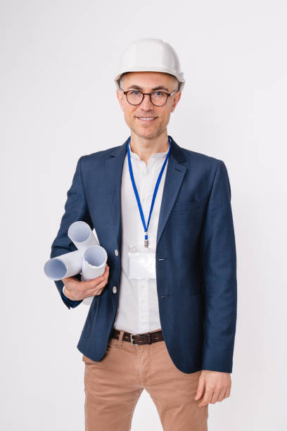 istock Vertical portrait of a handsome mature engineer with architercural plans isolated over white background 1306498328