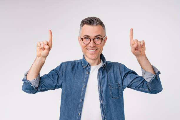 istock Cheerful caucasian mature man pointing at copy space isolated in white background 1306498549