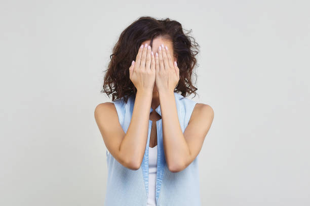 istock the dark-haired girl covered her eyes with her hands. 1306498585