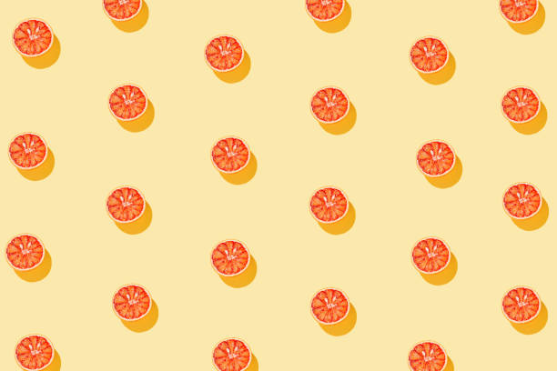 istock Creative pattern made with half of blood orange on yellow background. Summer fruit   concept. Minimal style. Sunlit flat lay. Top view 1306499148