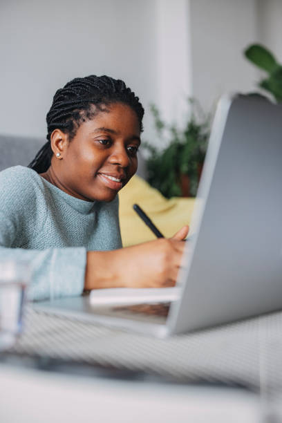 istock Women in Business: A Smiling Businesswoman Using a Laptop while Working from Home 1306500180