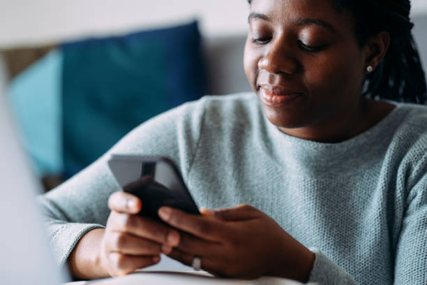 istock Women in Business: A Young Businesswoman Using a Mobile Phone while Working from Home 1306500235