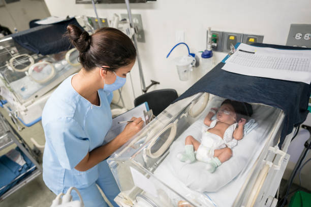 istock Nurse checking on a premature newborn in an incubator while wearing a facemask 1306500546