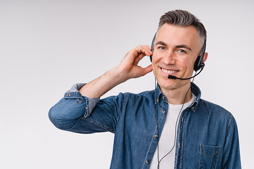 Cheerful mature caucasian man hotline worker it support in headset isolated in white background