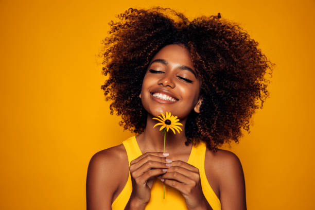 istock Beautiful afro woman with a flower 1306501910