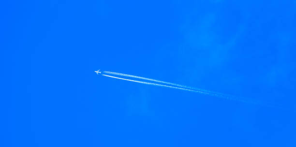 aereo a reazione in volo con scia di vapore. aereo di linea che vola nel cielo blu. sagoma di aerei che volano tra le nuvole e lasciano contrail, sentiero di condensazione. - cumulus cloud condensation sky blue foto e immagini stock