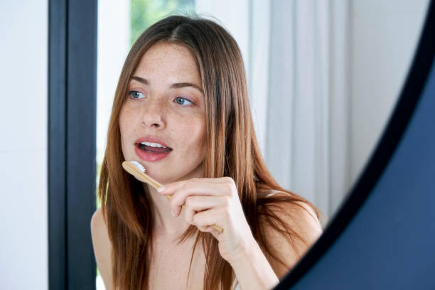 close up of young woman brushing her teeth at home - brushing teeth women toothbrush brushing imagens e fotografias de stock