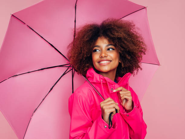istock Afro girl with pink umbrella 1306502280