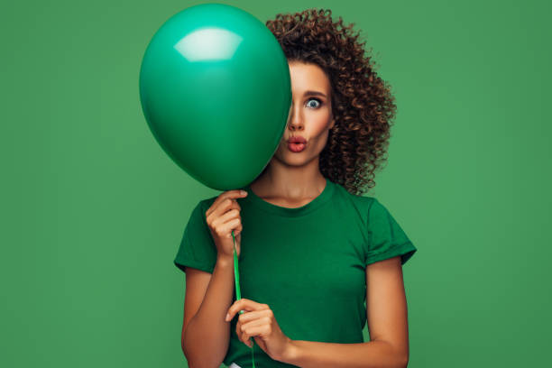 istock Surprised beautiful woman holding a green balloon 1306503376