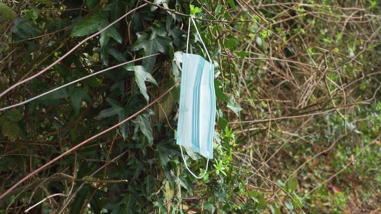 A used discarded mask on a wire fence in a rural countryside