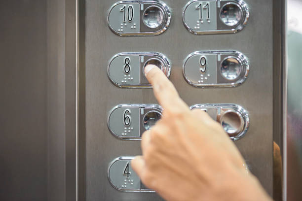 istock Close-up of man's finger pushing elevator button on wall 1306504111