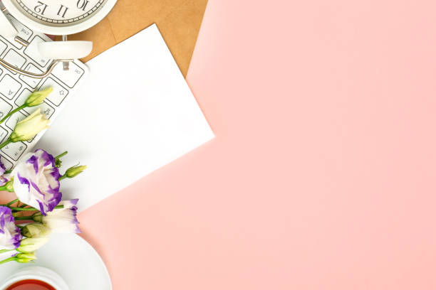 istock Beautiful romantic floral composition. Spring flowers, keyboard and alarm clock on pink background. Space for text 1306505374