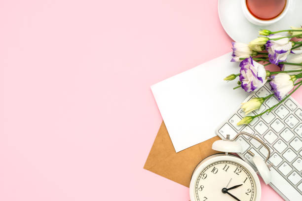 istock Beautiful romantic floral composition. Spring flowers, keyboard and alarm clock on pink background. Space for text 1306505375