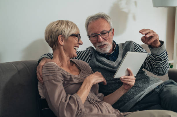 istock Cheerful senior couple using digital tablet together at home 1306507615