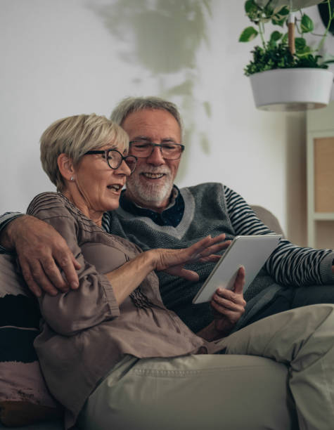 istock Cheerful senior couple using digital tablet together at home 1306507616