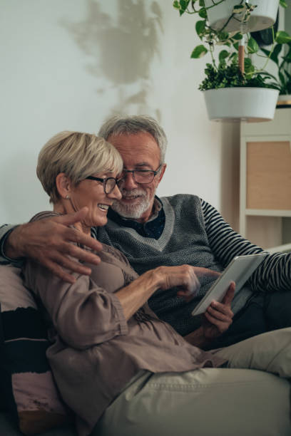 istock Cheerful senior couple using digital tablet together at home 1306507617
