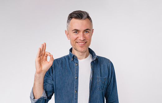 Confident mature white man showing okay sign isolated over white background