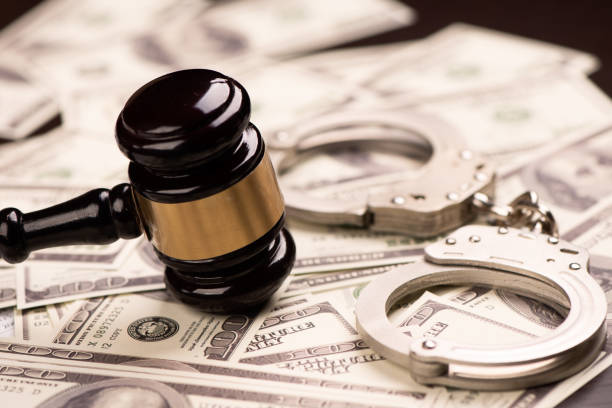 istock Hammer judge, handcuff and dollars on wooden table 1306510296