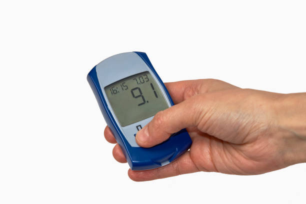 istock Hand holding glucometer with blood sugar test result. 1306510445