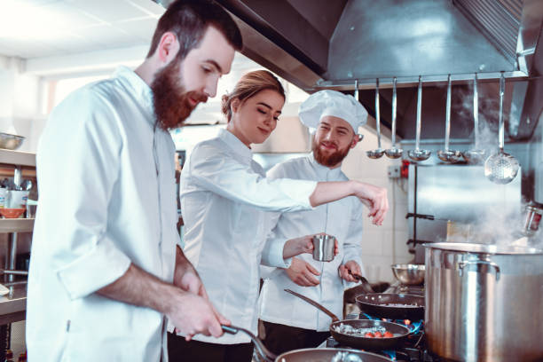 istock Seasoning Time In Modern Kitchen By Chef And Two Supportive Cooks 1306510805
