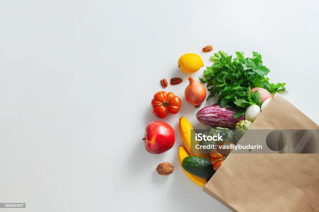 Healthy food background. Healthy vegan vegetarian food in paper bag vegetables and fruits on white, copy space, banner. Shopping food supermarket and clean vegan eating concept Healthy food background. Healthy vegan vegetarian food in paper bag vegetables and fruits on white, copy space, banner. Shopping food supermarket and clean vegan eating concept. Vegetable Stock Photo