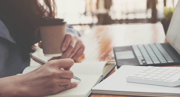 istock Business woman hand is writing on a note pad with a pen. 1306511860
