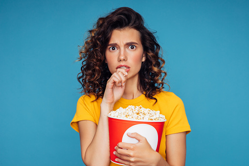 Close-up photo of a beautiful woman holding a big pop corn box container