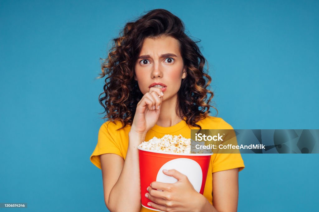 Close-up photo of a beautiful woman holding a big pop corn box container Popcorn Stock Photo
