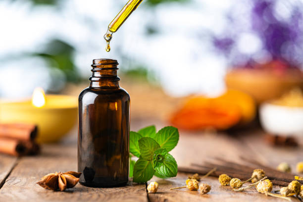 アロマヘラピー:木製テーブルにエッセンシャルオイルボトル - aromatherapy oil aromatherapy massage oil bottle ストックフォトと画像
