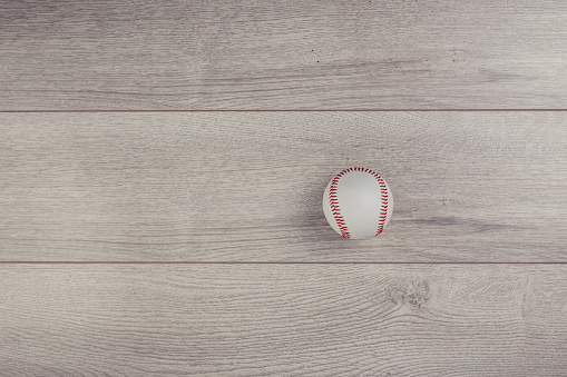 Baseball ball on wooden table background, flat lay concept. No people.