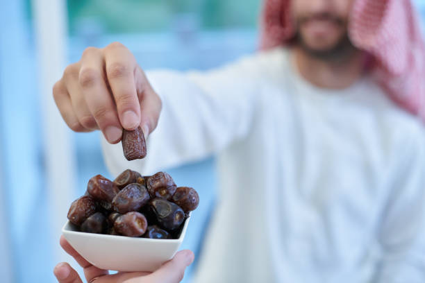 istock Muslim couple sharing dates for starting iftar 1306515542