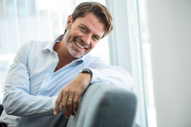 istock Smiling mature businessman leaning on sofa 1306515547