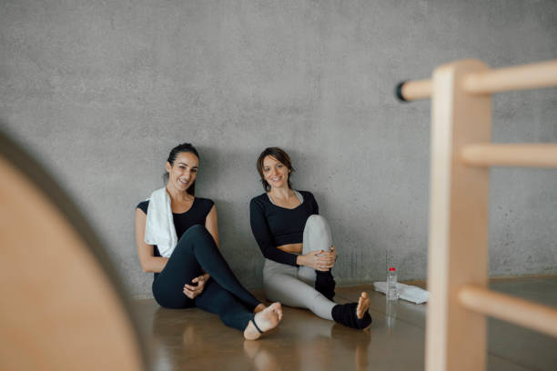 istock Female pilates coaches taking a break between classes and smiling at camera. 1306517139
