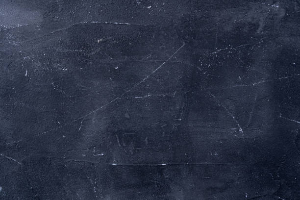 istock Dark background of old black plaster, grunge texture 1306518089