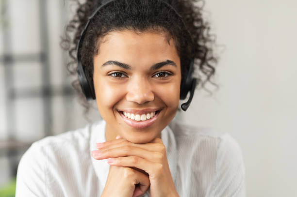 jovem afro-americana usando um fone de ouvido - women on the phone headset service - fotografias e filmes do acervo