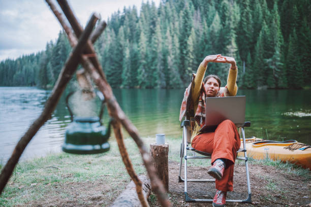 istock Young beautiful woman using her laptop for work, while camping in the nature. 1306518408