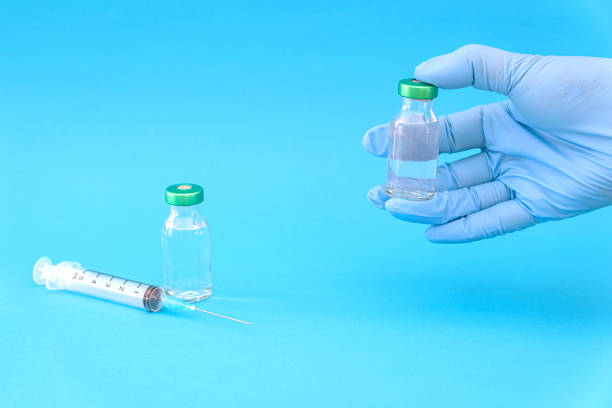 istock Potential trials stage concept on blue background. Close up Vials with sterile needle syringe. Research and Development, Vaccination. 1306519772