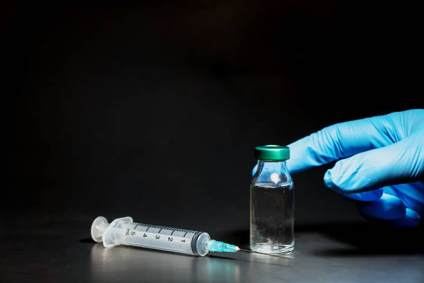 istock Potential trials stage concept on black background. Close up Vials with sterile needle syringe. Research and Development, Vaccination 1306519785